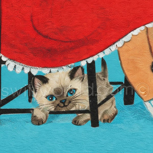 A Siamese cat with blue eyes is peeking out from under a red tablecloth, with a person's arm visible on the right side of the image.