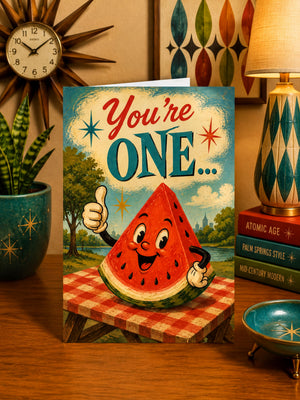 a greeting card with a watermelon character giving a thumbs up, surrounded by various decorative elements such as a clock, a lamp, and a bowl.