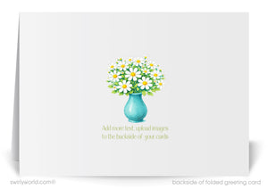 A white greeting card with a blue vase containing a bouquet of white and yellow flowers. The card has a text overlay that encourages adding more text or images to the backside of the card.