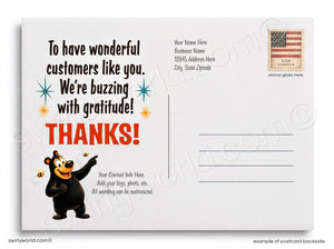The image is a postcard with a cartoon bear and a message expressing gratitude. The postcard has a blank space for a recipient's name and address, and a stamp in the top right corner. The text on the postcard is a personalized message, and the image is a collage of various images, including a bear and a bee. The text on the postcard is not described in detail, and the phrase "To have wonderful customers like you. We're buzzing with gratitude!" is the main message.