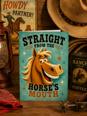 a card with a cartoon horse and the text "Straight from the horse's mouth" on a wooden surface, surrounded by various western-themed items such as a cowboy hat, a lantern, and a can of ranch coffee.