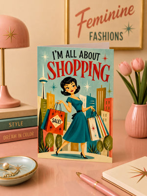 a card with a woman carrying shopping bags, surrounded by a cityscape and a pink lamp, with a pink vase of flowers and a pink notebook on a desk.