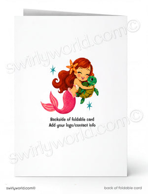A folded greeting card shown front and back on a white background. The front features a cartoon mermaid with red hair and a pink tail hugging a green sea turtle, with small blue star accents.