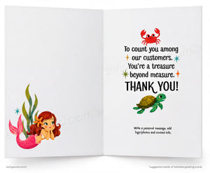 An open greeting card with a white interior. The left page shows a cartoon mermaid with a pink tail and green seaweed.