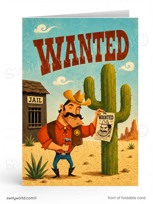 A folded card featuring a retro western 'WANTED' poster design, shown standing upright on a white background. The illustration includes a cowboy holding a wanted poster next to a cactus and jailhouse.
