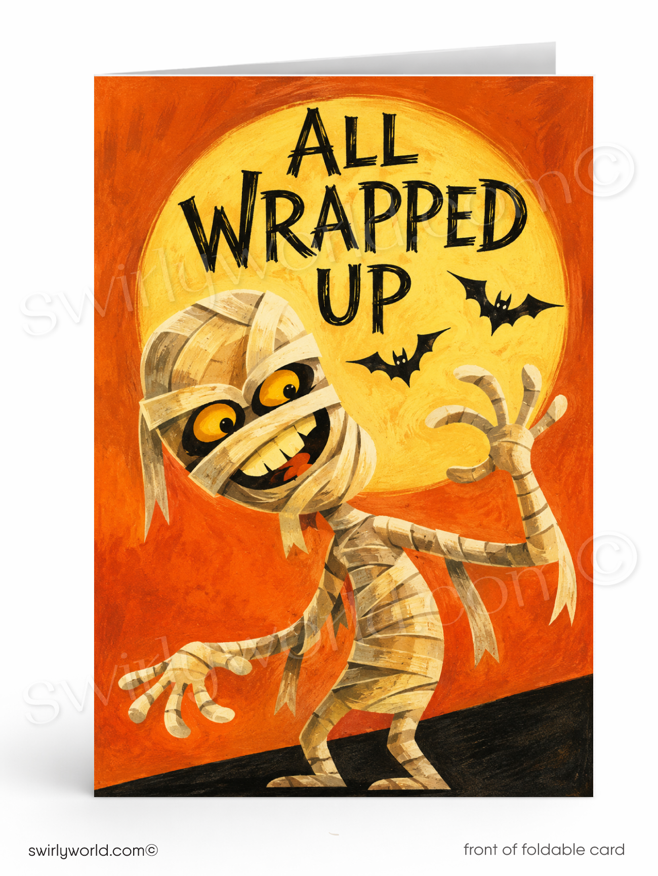 A folded greeting card shown upright on a white background, featuring a Halloween design with the text 'ALL WRAPPED UP' above a mummy figure against an orange and yellow background with small bats.