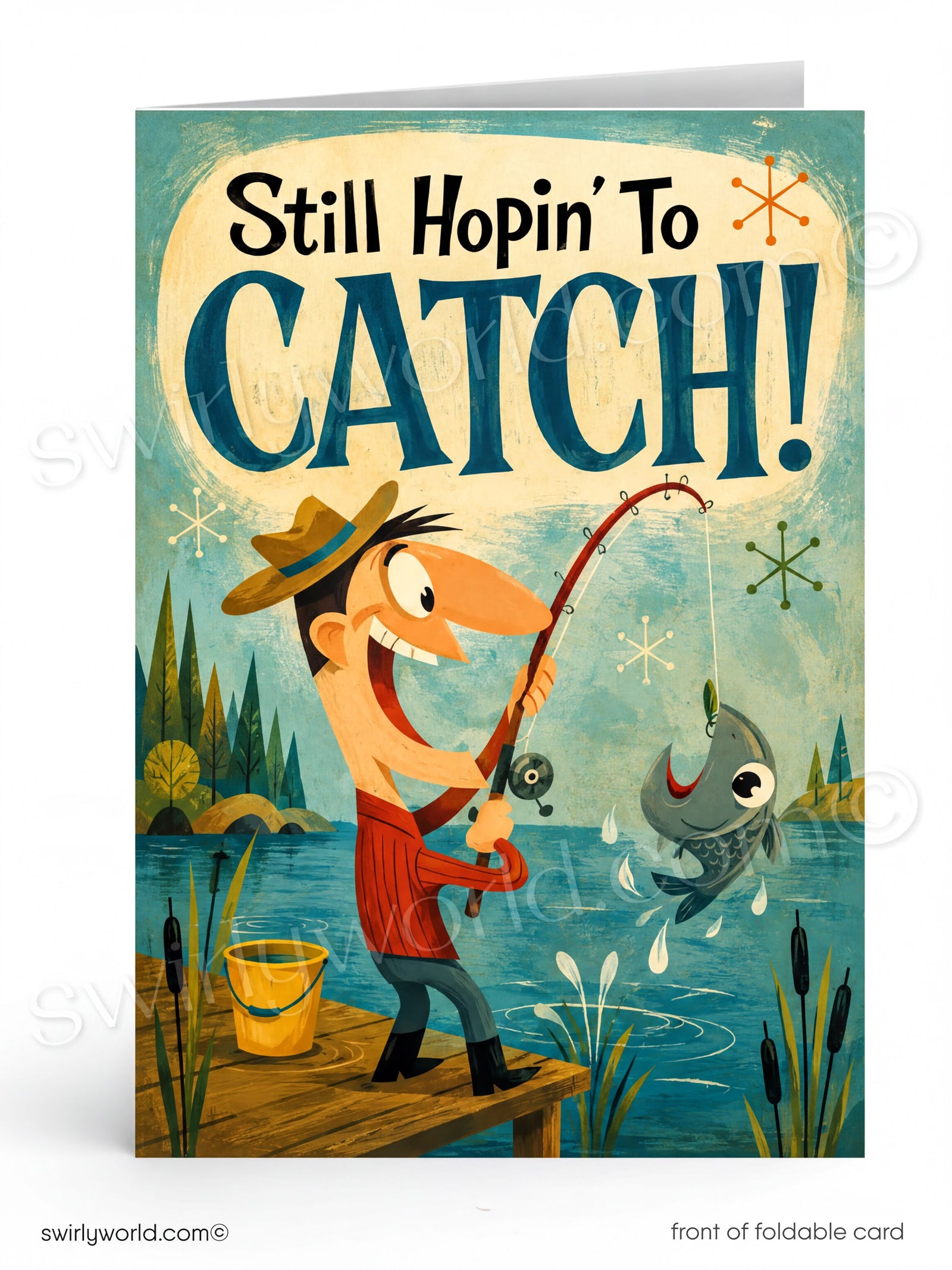 A folded greeting card shown front-on against a white background. The card features a whimsical illustration of a man fishing from a dock by a lake, with the text 'Still Hopin' To CATCH!' at the top.