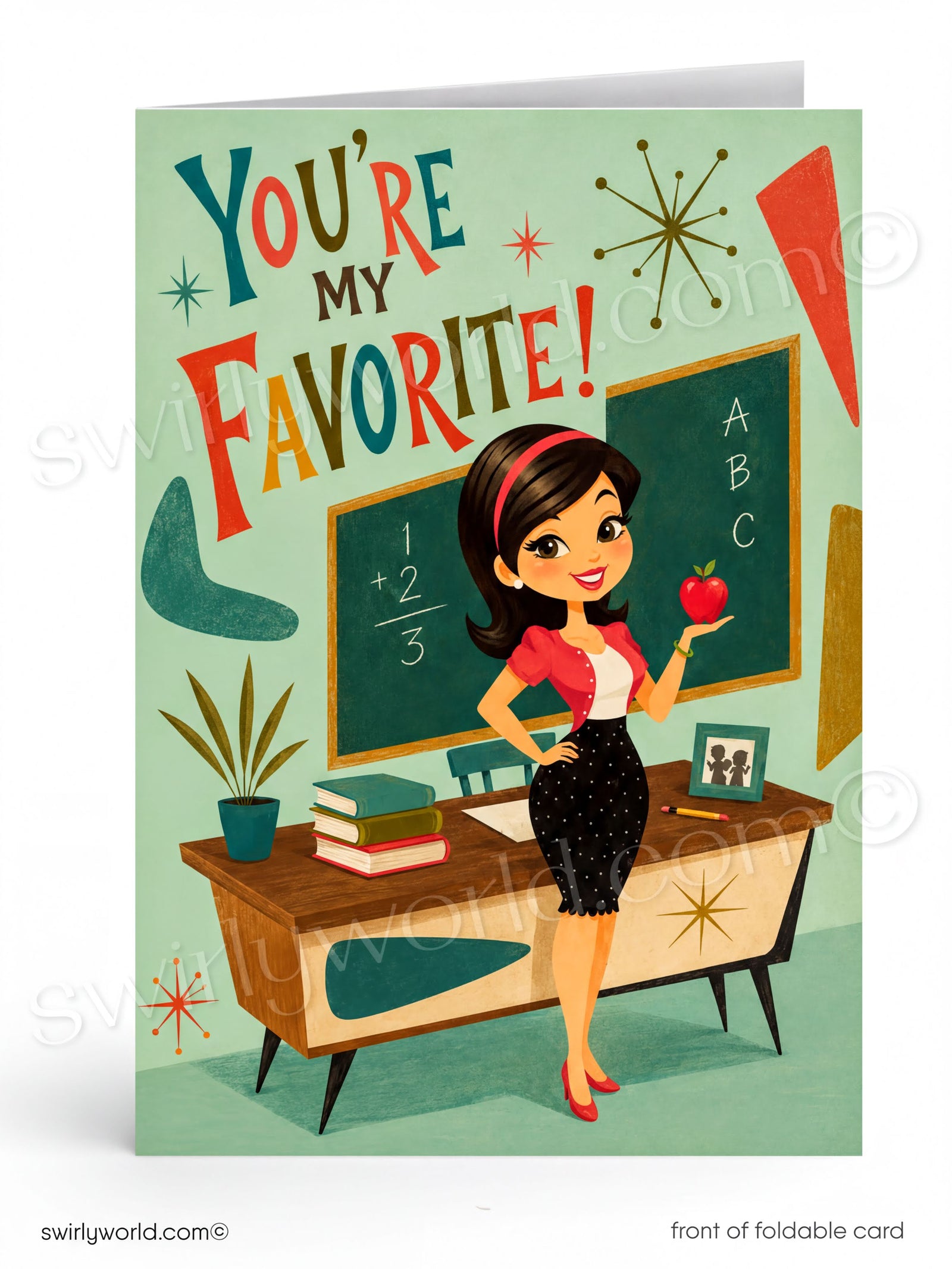 A folded greeting card shown upright on a white background. The card features a retro-style illustration of a smiling woman standing in a classroom, holding an apple near a chalkboard and desk.