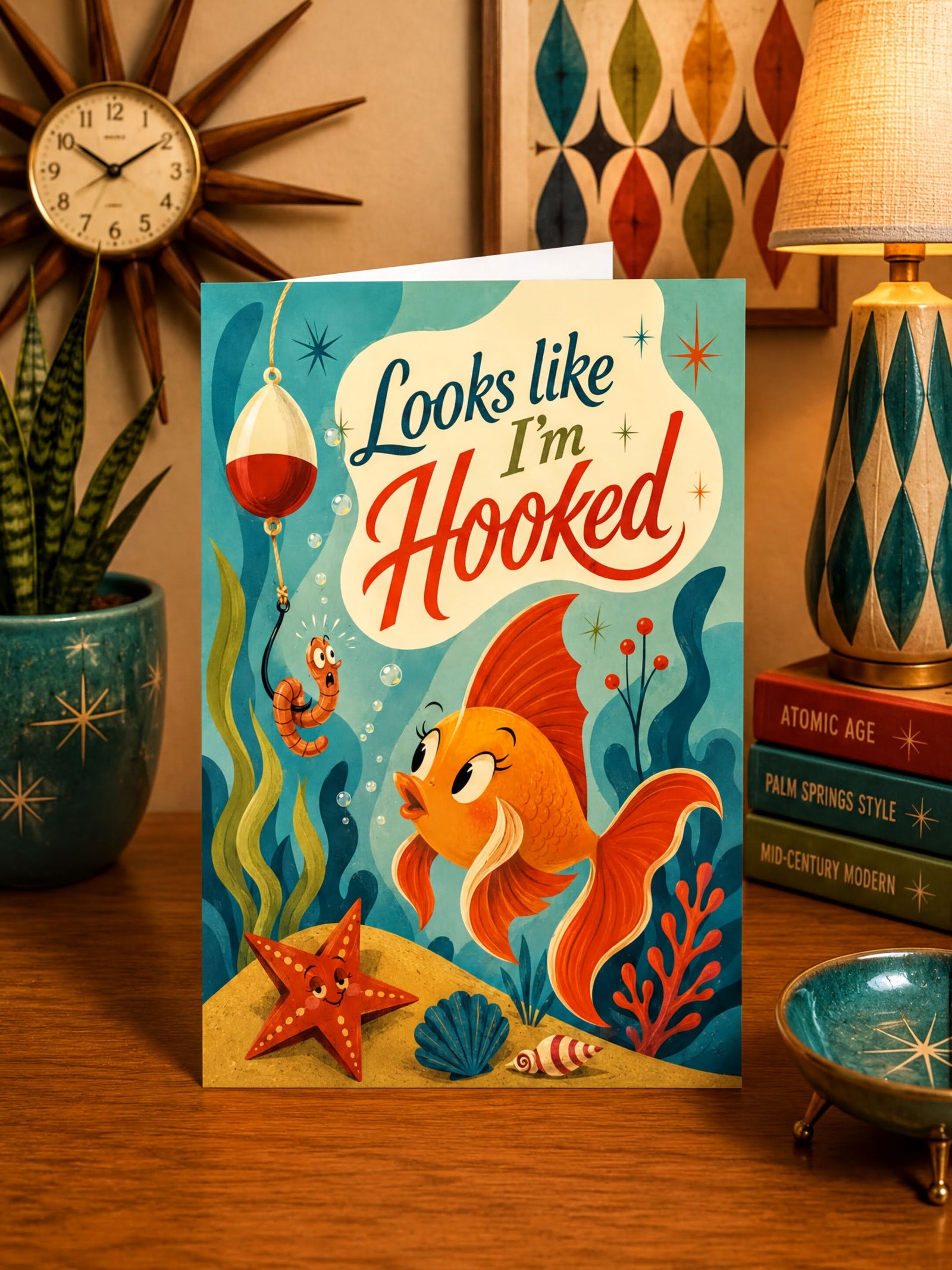 Card with a fish and worm character underwater, text 'Looks like I'm Hooked', colorful design