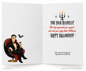 An open greeting card shown front and back. The left panel features a cartoon vampire sitting in a red chair and holding a drink, with a bat flying nearby.