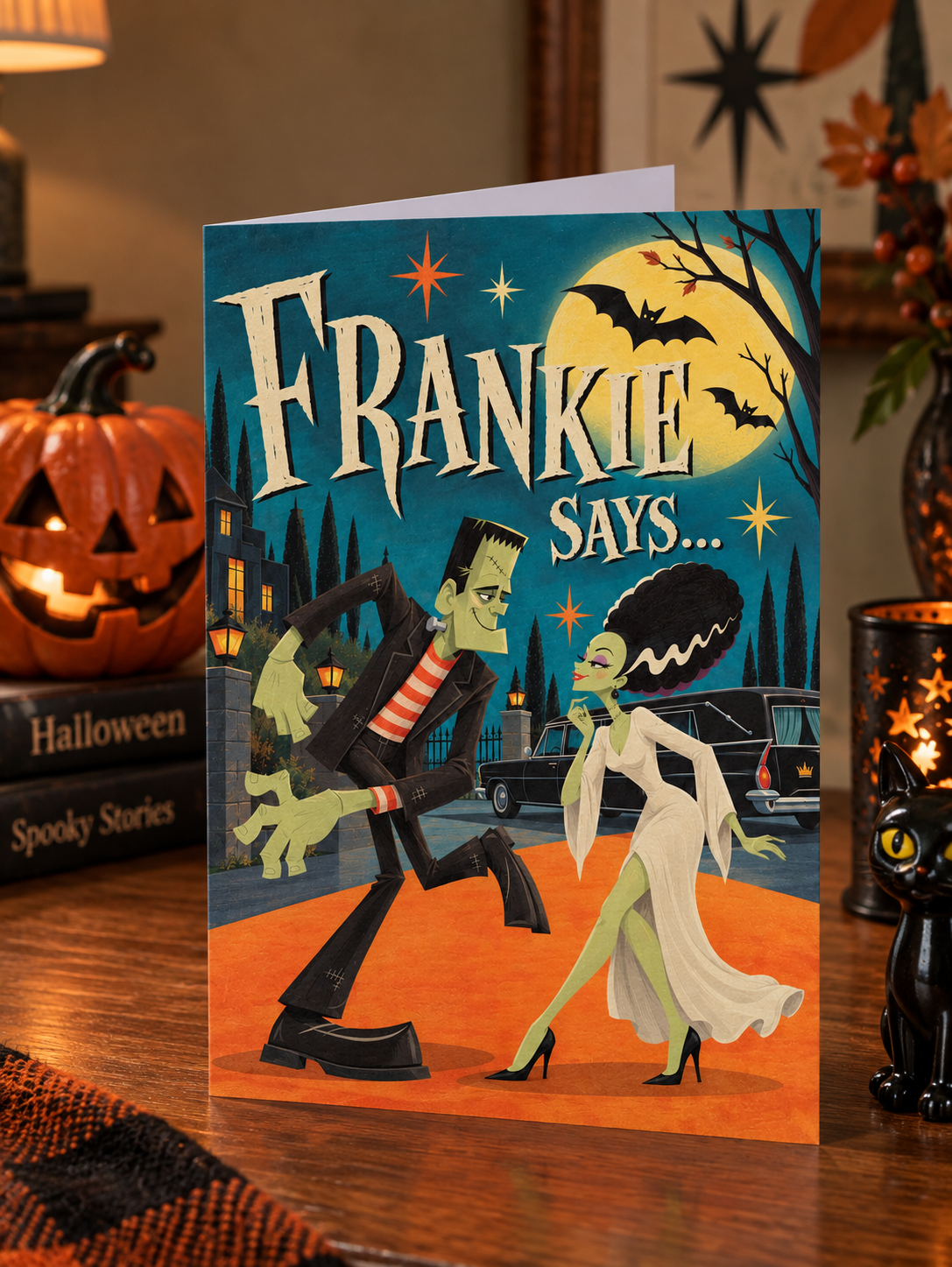 A folded greeting card shown front-on against a white background. The card artwork features a Halloween night scene with the large text 'FRANKIE SAYS.
