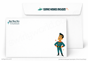 A set of white printed envelopes shown on a light gray background. The front envelope has a cartoon superhero illustration in a blue and red costume with small star accents, and the back envelope has a small space-themed graphic with the text 'COSMIC WISHES ENCLOSED'.