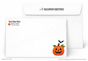 White Halloween greeting stationery set showing the front of a letterhead envelope and matching card. The card has a small orange jack-o'-lantern with green leaves and a black bat in the lower right corner, and the envelope has 'HALLOWEEN GREETINGS!' printed at the top with a small starburst icon.