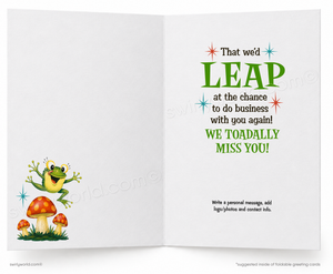 An open greeting card with a white background. The left panel shows a cartoon green frog jumping above red mushrooms.