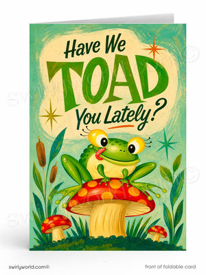 A folded greeting card shown upright on a white background. The front features a whimsical illustration of a green frog sitting on a red-and-yellow mushroom, with the text 'Have We TOAD You Lately?' in large green and black lettering on a light cream shape behind it.