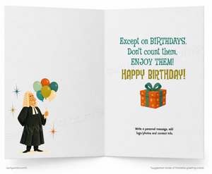 An open greeting card with a white interior layout. The left panel shows a cartoon judge in a black robe holding a cluster of colorful balloons.