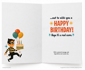 An open greeting card with a birthday message on the right panel and a cartoon thief carrying a cake on the left panel. The card has a white background with orange, teal, yellow, and black printed graphics and text.