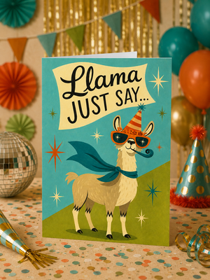 A birthday greeting card featuring a cartoon llama wearing a party hat and cape with the text 'Llama JUST SAY.