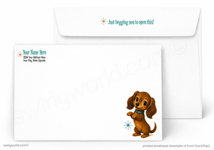 A printed white envelope set shown on a light gray background. The front envelope has a cartoon dachshund illustration near the lower right, a small blue snowflake, and sample text including 'Just begging you to open this!' on the flap.