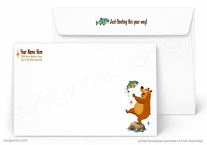 A printed white envelope set shown on a light gray background. The front envelope has a cartoon brown bear catching a green fish on a rock, with small sample text on the left.