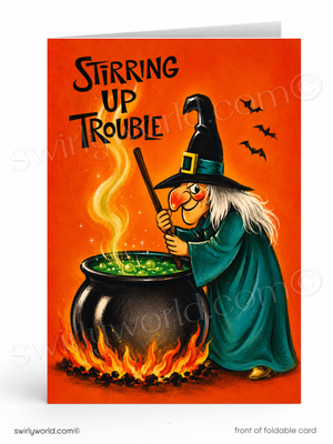 A folded Halloween greeting card shown front-facing on a white background. The card features an orange background with the text 'STIRRING UP TROUBLE' above a witch in a teal robe and black hat stirring a bubbling cauldron with flames beneath it.
