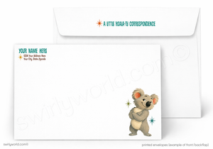 A white stationery set showing a printed envelope in front of a plain white envelope. The front envelope has a cute cartoon koala near the lower right corner, teal placeholder text reading 'YOUR NAME HERE' and '1234 Your Address Here Your City, State, Zip Code,' and teal text on the flap reading 'A LITTLE KOALA-FI CORRESPONDENCE.
