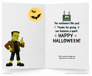 An open folding greeting card design for Halloween, showing a cartoon Frankenstein character on the left and printed greeting text on the right, with a yellow moon and bats in the background.