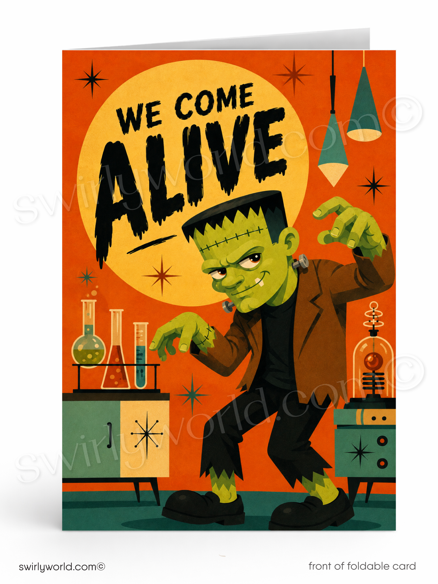 A folded greeting card shown front-facing on a white background. The card features a retro-style illustration of Frankenstein's monster in a lab with the text 'WE COME ALIVE' over a large yellow moon on an orange background.