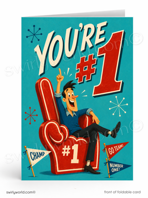 A folded greeting card shown front-on against a white background. The card features a retro-style illustration with the text 'YOU'RE #1' in large white and red lettering, a cartoon man sitting on a red foam finger chair, and small flags reading 'CHAMP', 'GO TEAM!', and 'NUMBER ONE'.