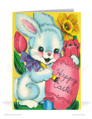 Charming vintage Easter card with a bunny in a purple bow writing on a pink egg. Bright yellow 1950s floral backdrop with tulips, lilies & retro flair!