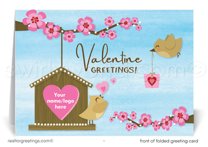 This Valentine's Day greeting card charmingly displays a birdhouse with a pink heart-shaped entrance, where a joyful little bird perches on the branches of a cherry tree, symbolizing the warmth of a home. Another bird approaches, carrying a Valentine's Day gift, adding a playful and joyful element to the scene.